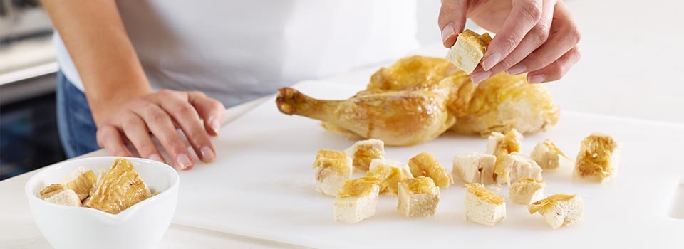 Chicken being diced on cutting board